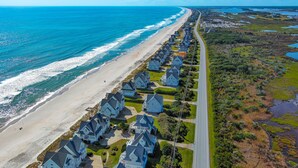 Una zona residenziale lungo la costa, con case allineate lungo una strada, una spiaggia e vista sull'oceano.