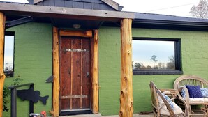 A rustic building with a wooden door, green walls, and a window. - Lake view, close to shopping, hiking, restaurants and boat launch. (Guntersville)