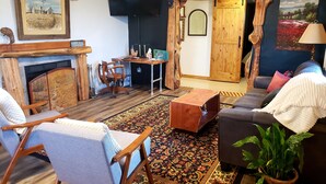 A cozy living room with a fireplace, a sofa, a coffee table, and a rug. - Lake view, close to shopping, hiking, restaurants and boat launch. (Guntersville)