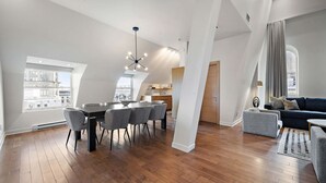 Un appartement moderne de style « loft » comprenant un coin repas, une cuisine et un espace de vie.
