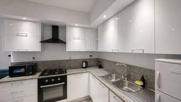 Apartemen Comfort | Dapur pribadi | Lemari es, microwave, dan mesin pencuci piring