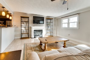 A modern living room with a fireplace, a television mounted above it, and a wooden coffee table. - Updated Robinson Vacation Rental w/ Fireplace! (Robinson)