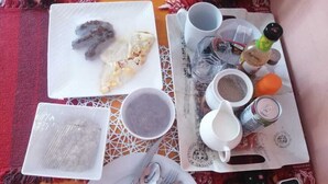 Ein Frühstückstisch mit Geschirr, Speisen und Beilagen.