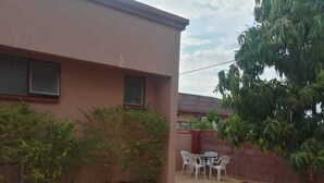 Ein modernes Haus mit Terrasse, einem kleinen Garten und einem Essplatz.