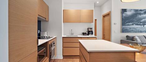 A modern kitchen with wooden cabinets, a central island, and a dining area with a table and chairs.
