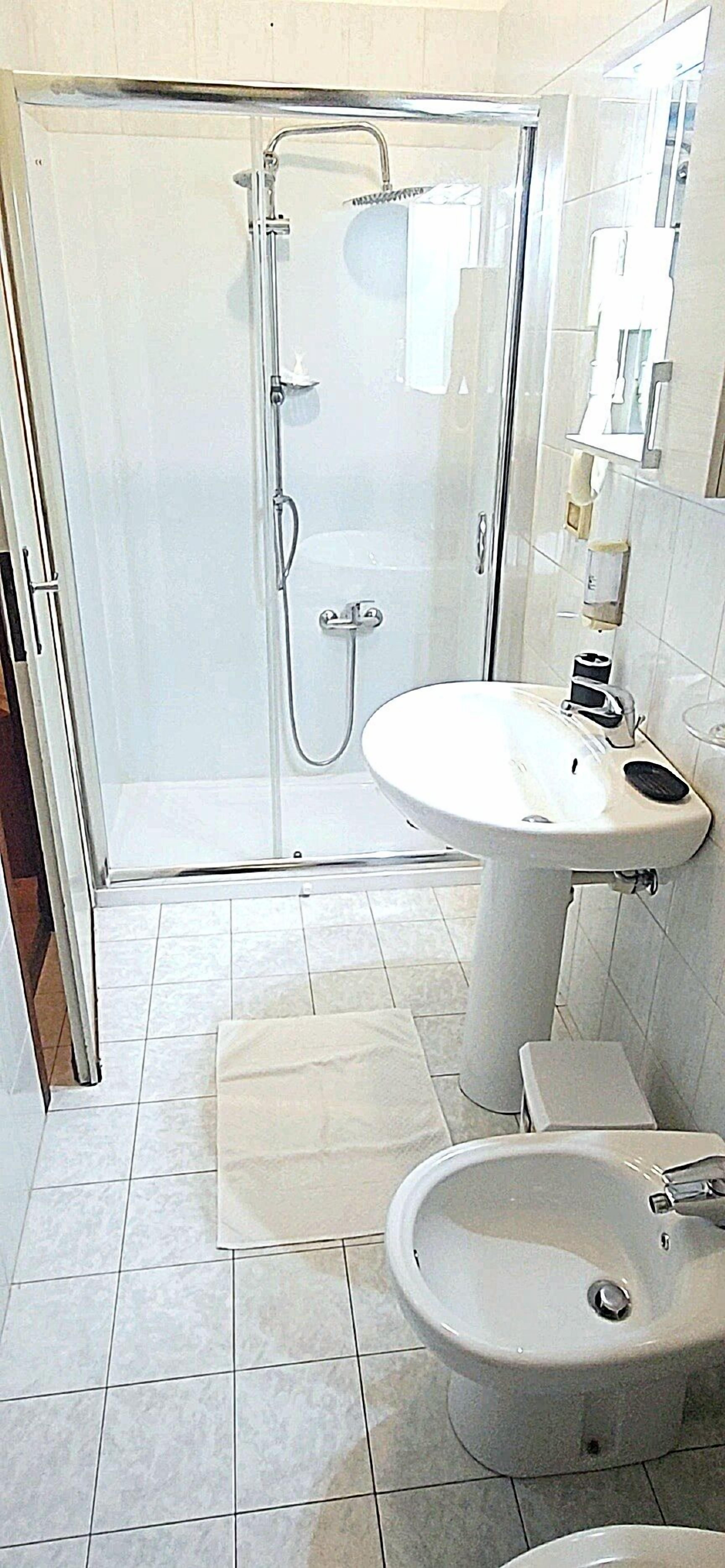 Un baño con ducha, lavabo y bidé.