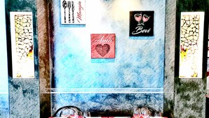 A dining table set with wine glasses, plates, and cutlery. There are framed signs on the wall with names and a heart symbol. - Hotel Ristorante delle Valli  (Germagnano)