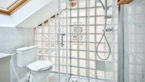 A modern bathroom with a glass shower enclosure, a white toilet, and a skylight. - 01.Duplex near Tour Eiffel & Montparnasse Station (Paris)