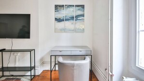A modern living room with a white sofa, a black TV stand, a white table, and a large abstract painting on the wall. - 22.Appartement 6Pers#Sèvres-Lecourbe#Champ-de-Mars (Paris)