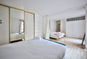A bedroom with a large bed, a wardrobe, and a separate bed in the background. - 22.Appartement 6Pers#Sèvres-Lecourbe#Champ-de-Mars (Paris)