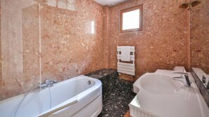 A bathroom with a marble wall, a bathtub, a sink, and a window. - 22.Appartement 6Pers#Sèvres-Lecourbe#Champ-de-Mars (Paris)