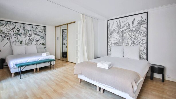 A bedroom with a bed, a bench, and a nightstand. - 22.Appartement 6Pers#Sèvres-Lecourbe#Champ-de-Mars (Paris)
