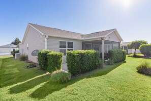 A single-story house with a covered porch, a satellite dish, and well-maintained landscaping. - Ranch Retreat: Luxury Living in Village Charm! (The Villages)