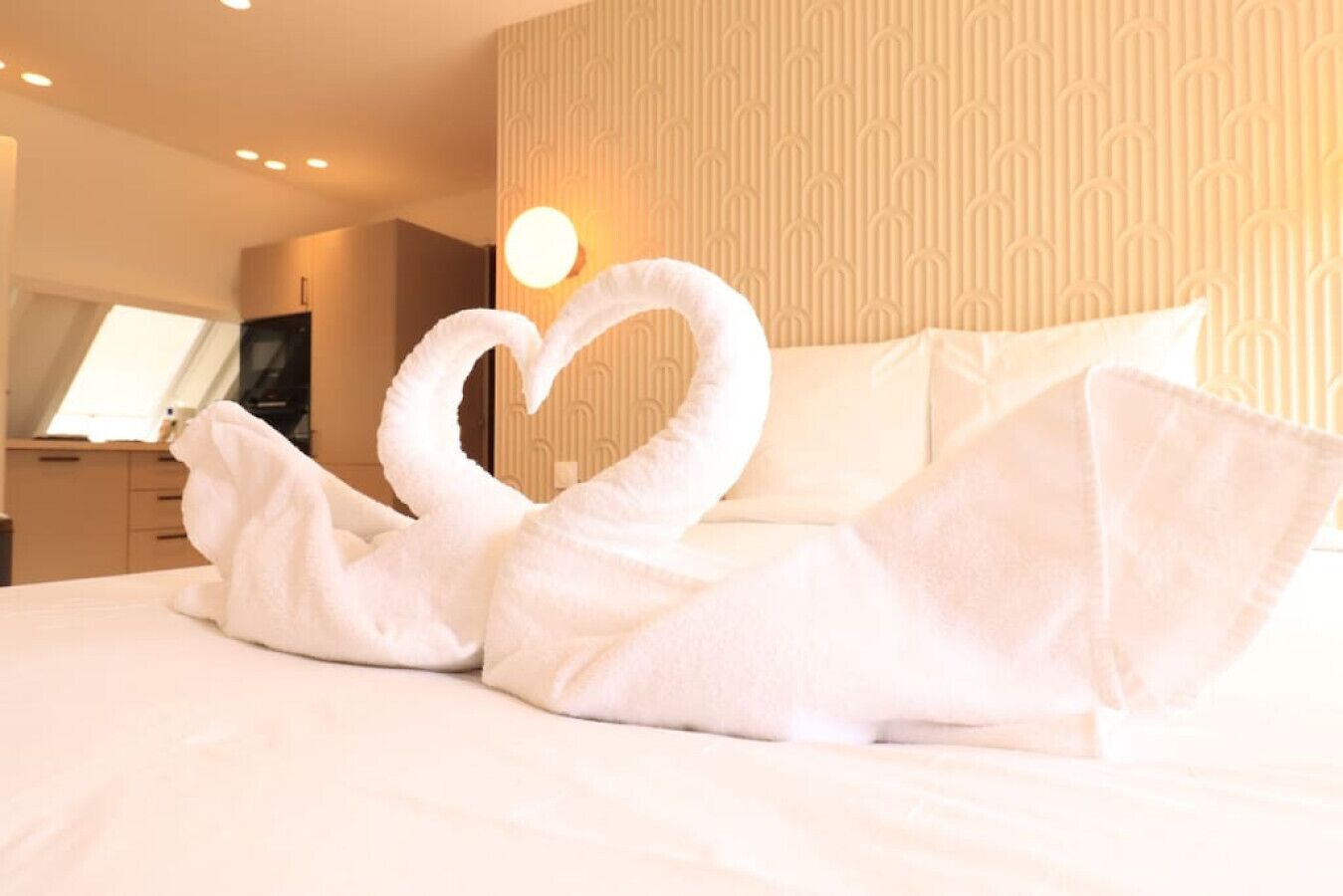 Ein Bett mit einem in Schwanform drapiertem Handtuch.