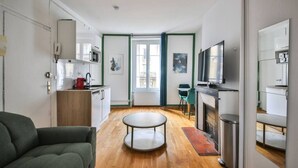 A compact living space with a kitchen, dining area, and seating. - 21.Studio 2Pers#Sèvres-Lecourbe#Champ-de-Mars (Paris)