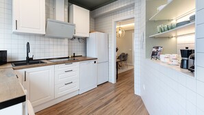 A modern kitchen with white cabinetry, a wooden countertop, and a built-in oven. - Genteel Home Jovellanos Terrace (Gijon)