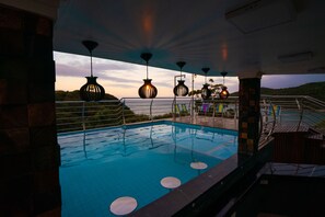 Una piscina al aire libre, sillones reclinables de piscina