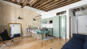 Een moderne keuken met een stenen muur, een bar met krukken en een houten plafond.