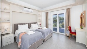 Ein modernes Hotelzimmer mit zwei Betten, einem Balkon und einem Schreibtisch.