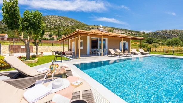 Ein Poolbereich mit Liegestühlen und einer überdachten Terrasse.
