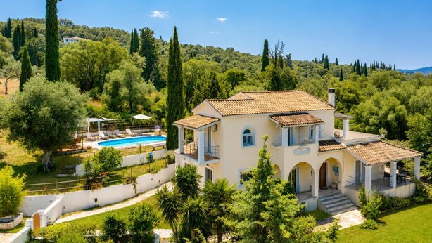 A villa with a swimming pool, surrounded by lush greenery and tall trees. - Villa Mavrikia - Four Bedroom Villa, Sleeps 8 (Sfakera)