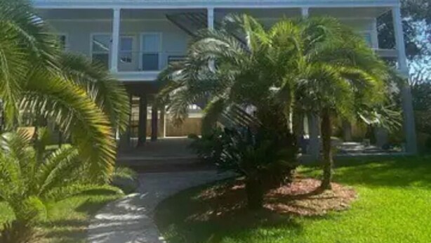 Un edificio de dos plantas con fachada simétrica, varios ventanales y una entrada central.