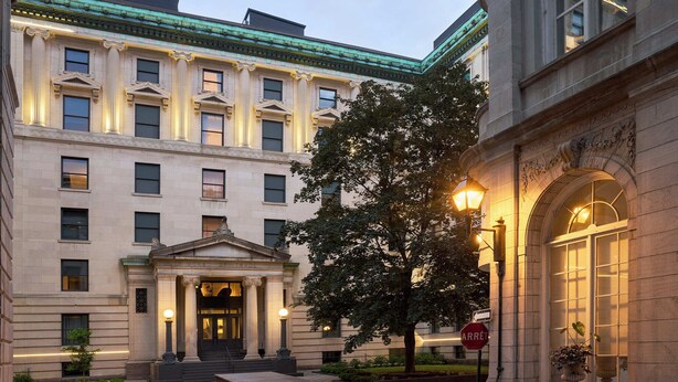 Un edificio de estilo arquitectónico clásico, con una entrada destacada que incluye columnas y un cartel que dice 'Board of Trade'.