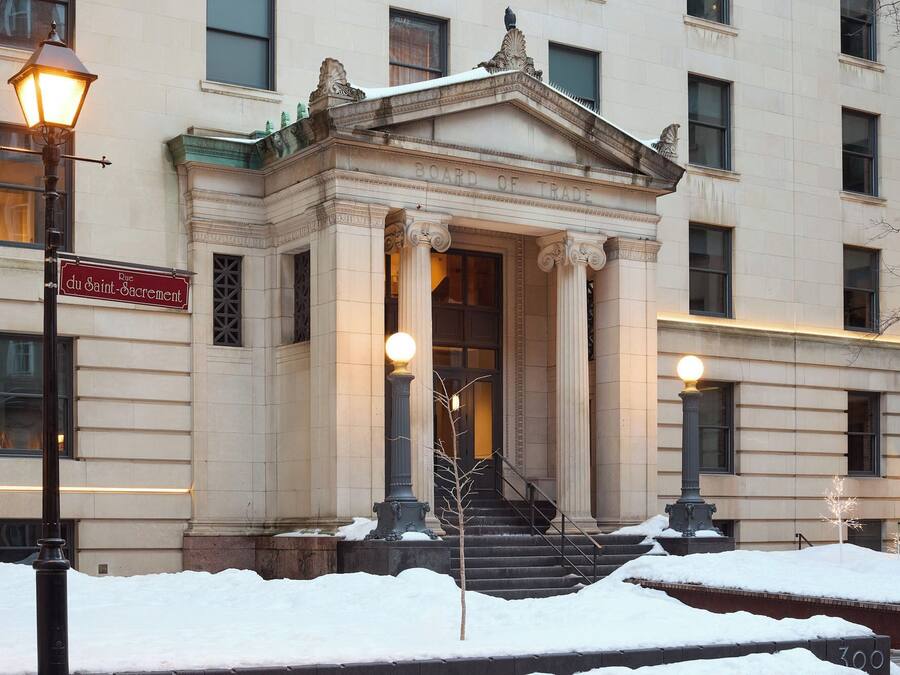 A classical building with a sign reading 'Board of Trade' and 'RUC du Saint-Sacrement.'