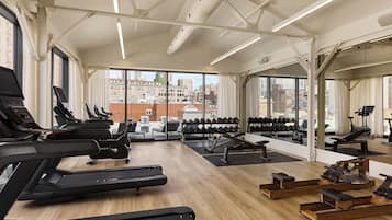 A gym with treadmills, weight machines, and a rowing machine.