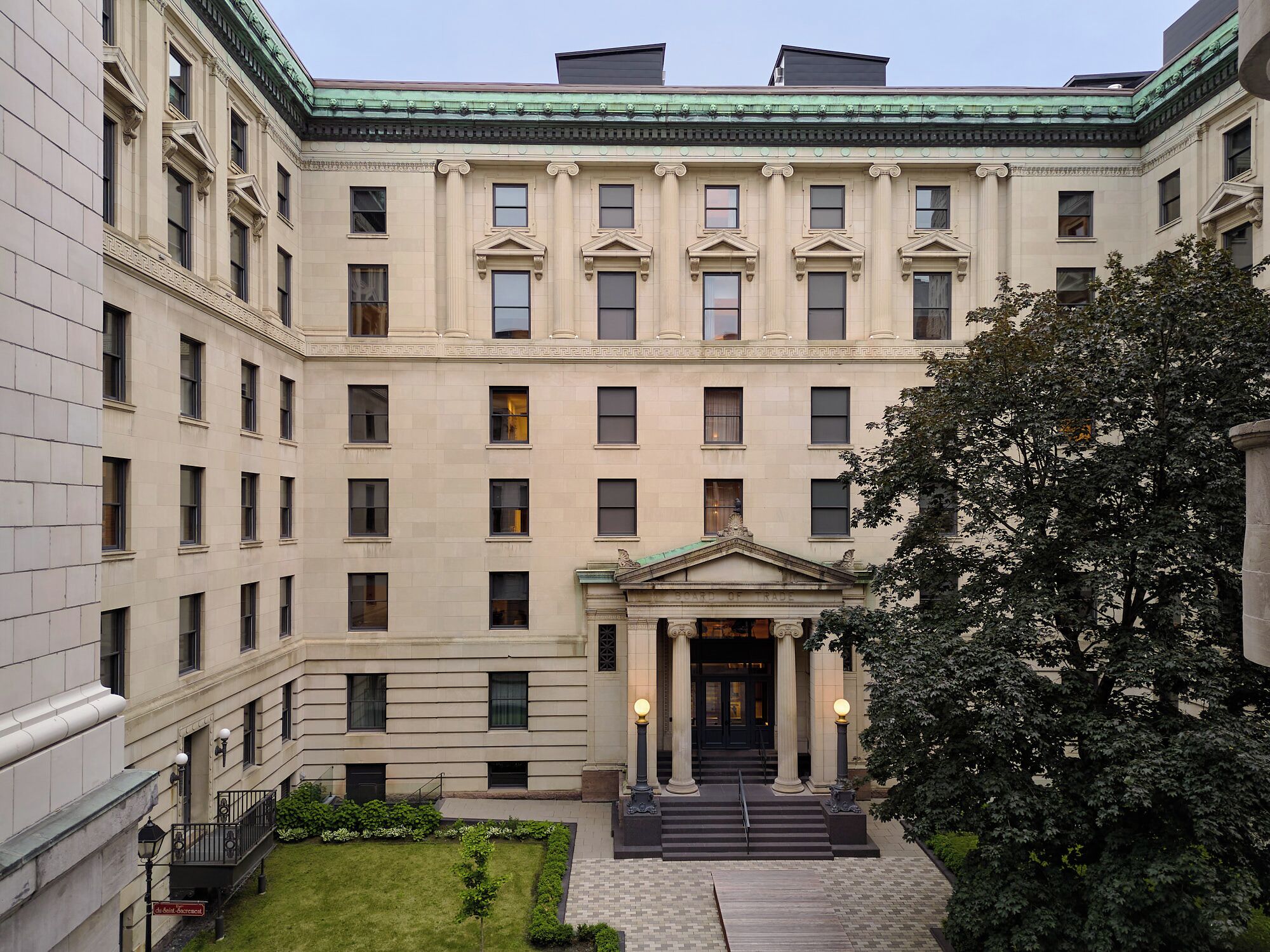 Un edificio de varios pisos con fachada simétrica, ventanas amplias y una entrada central con columnas.