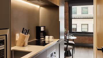 Una cocina moderna con estufa integrada, cafetera y bloque de cuchillos.