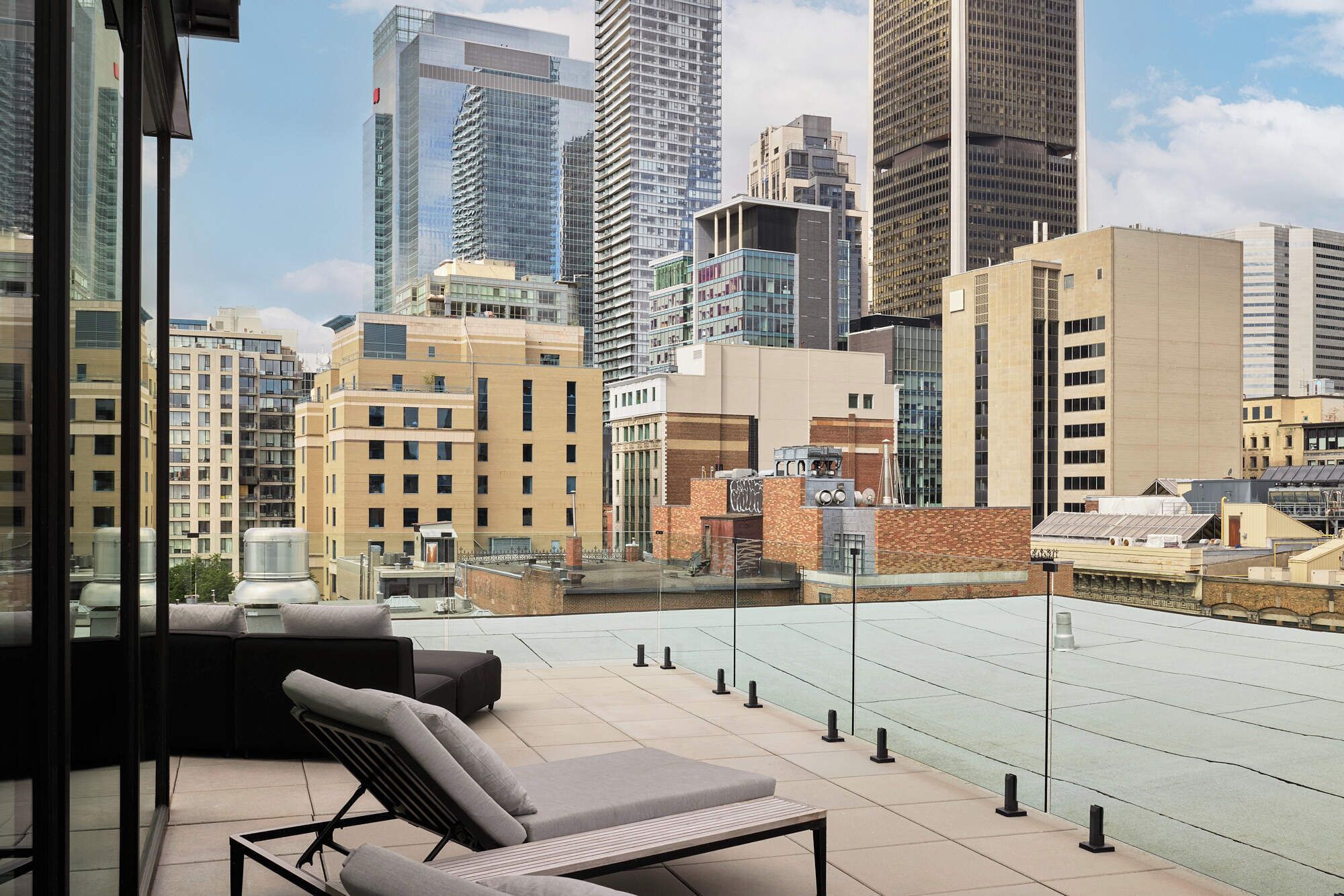 Una terraza en la azotea con vistas al horizonte de la ciudad, que incluye edificios modernos y altos.