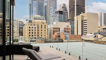 Una terraza en la azotea con vistas al horizonte de la ciudad, que incluye edificios modernos y altos.