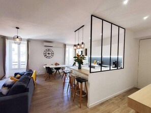 A modern apartment with a dining area, kitchen, and living space.