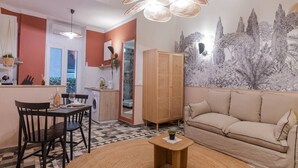A cozy living area with a sofa, a coffee table, and a dining table with chairs. There is a kitchen area with a washing machine and a cabinet. - Unique studio, Old Town Nice, 2min from the beach,AC (Nice)