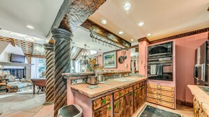 Una cucina con mobili in legno, una grande isola e una colonna in pietra.