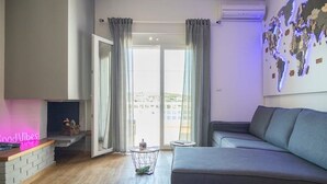 Un salon moderne avec un canapé gris, une cheminée et une carte du monde accrochée au mur.
