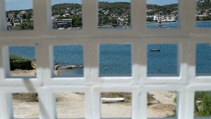 Une vue sur la côte, aperçue à travers une fenêtre à carreaux.