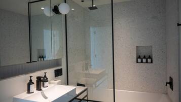 Een douche, designer toiletartikelen, een haardroger, handdoeken