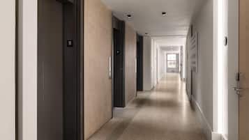 Un long couloir étroit, avec des portes des deux côtés, menant à différentes pièces.