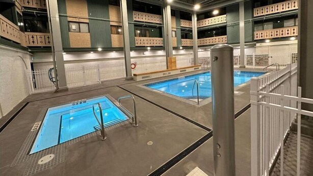 An indoor swimming pool area with multiple pools, a covered seating area, and a visible water filtration system. - One bedroom within 2 minute walk to Main Village.
 (Beaverdell)