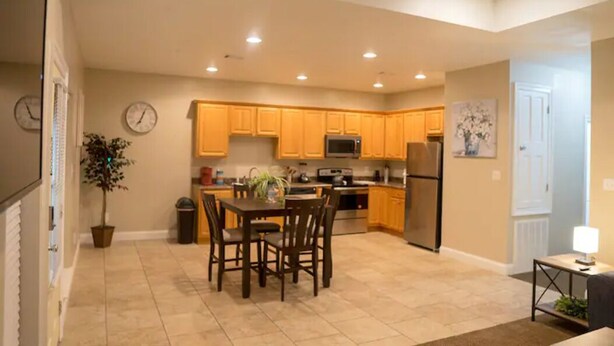 A modern kitchen with wooden cabinets, a dining table, and a ceiling fan. - Unit D (Moss Point)