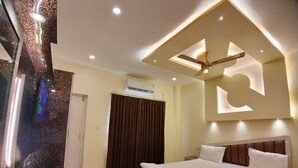 Une chambre moderne dotée d’un grand lit, d’un ventilateur de plafond et d’un système de climatisation intégré.