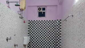 Une petite salle de bain avec des toilettes, une douche et une fenêtre.