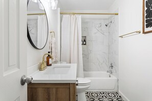 Ein Badezimmer mit einem weißen Waschbecken, einer Toilette und einer Badewanne.