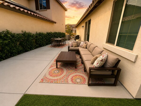 A patio with a sofa set, a table, and a patterned rug.