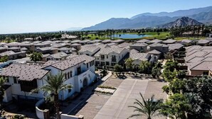 Zona residencial con casas, un patio central y un campo de golf al fondo.