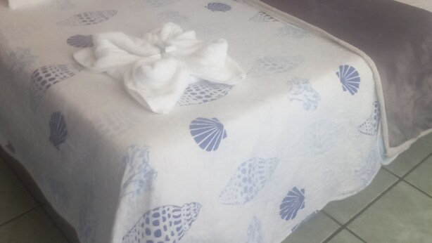 Una habitación de hotel con una cama, un tapiz azul y una pared de madera.