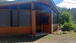 Un edificio de una planta con un porche, ventanas grandes y una puerta.
