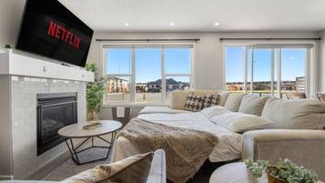 Een smart-tv, een open haard, boeken en een kantoor